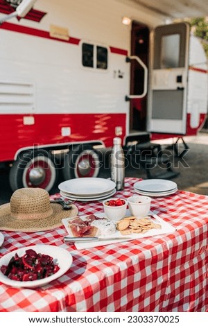 Charcuterie Board on a Red and White Table by an RV with Food