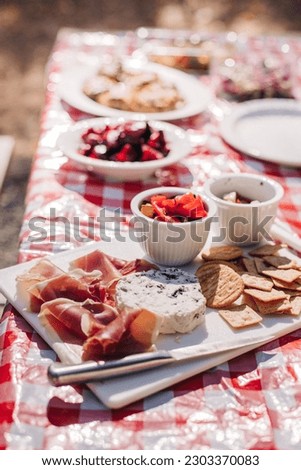 Charcuterie Board on a Red and White Table with Gourmet Food