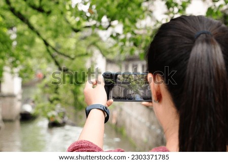 young woman having fun in local canal city in China with camera
