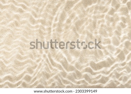 sun lights shadow in wavy water on abstract sand background, beautiful abstract spa concept banner of sea paradise island Royalty-Free Stock Photo #2303399149