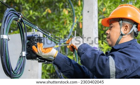 Engineer or technician checking fiber optic cables in internet splitter box.Fiber to the home equipment. FTTH internet fiber optics cables and cabinet.	 Royalty-Free Stock Photo #2303402045