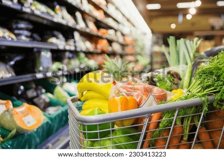 Close up of full shopping cart in grocery store Royalty-Free Stock Photo #2303413223