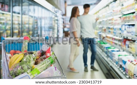 Defocussed view of couple shopping in grocery store Royalty-Free Stock Photo #2303413719