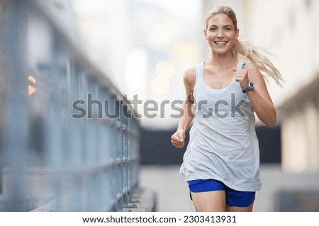 Woman running through city streets Royalty-Free Stock Photo #2303413931