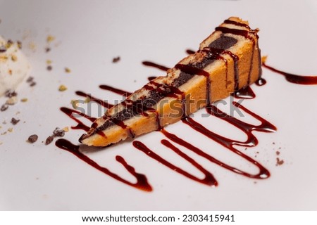 Tasty italian dessert, hot chocolate cake with sweet sauce and nuts on white board