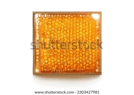 Honey in a honeycomb on wooden frame isolated on white background. Royalty-Free Stock Photo #2303427981