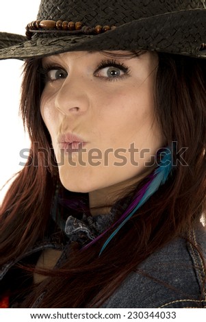 a close picture of a woman with her lips puckered in her cowgirl hat.