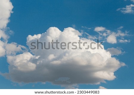 White fluffy clouds on a summer blue sky in cartoon style for background or wallpaper design. The background is white of round clouds in a blue sky.