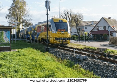 train on railway tracks in Hel city, Hel peninsula Poland Sikorskiego Street sing and Pharmacy directions visible with Plan of the city of Hel on the left side of the picture