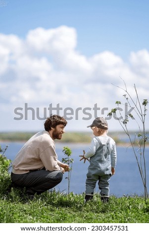 
European father communicates with his little son in nature in early spring