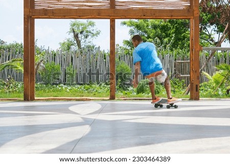 Man riding on skateboard, in summer park. 