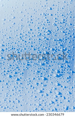 Raindrops on blue sky metal surface