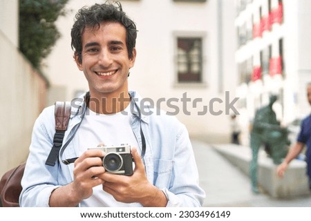 Young Caucasian man captures cherished memories with his vintage camera on a delightful vacation.