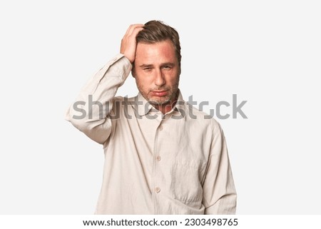 A middle-aged man isolated tired and very sleepy keeping hand on head.
