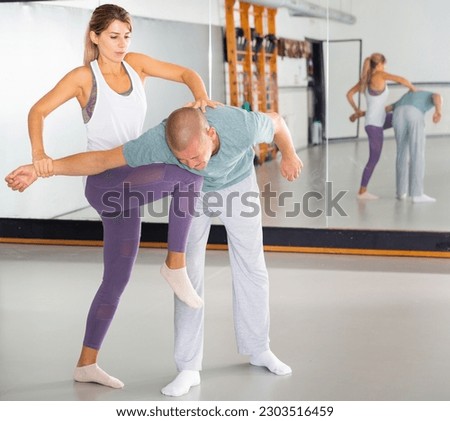Young woman paired up with male partner in self defense training, practicing basic attack movements and maneuvers..