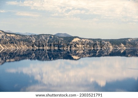 Quiet Morning Reflections of Clouds in Crater Lake from the Rim Trail Royalty-Free Stock Photo #2303521791