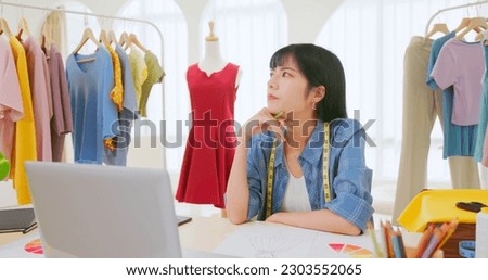 side view asian female fashion designer anxiety on creation inspiration - she draw and design clothes