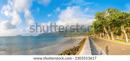 Panoramic coastal Con Dao island view from above, with waves, coastline ,clear sky and road, blue sea and mountain.