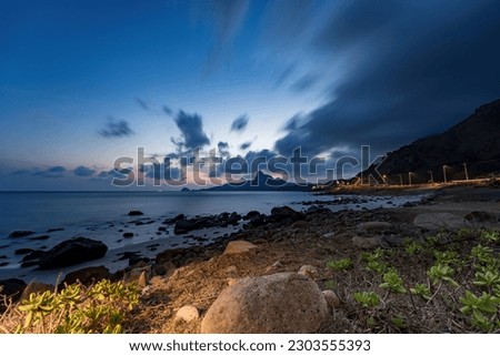 Panoramic coastal Con Dao island view from above, with waves, coastline ,clear sky and road, blue sea and mountain. Aerial view of Bai Nhat beach with cinematic sunset.