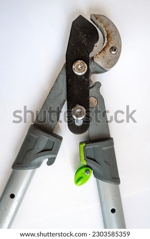 Close up of long handle garden tree branch shears, trimmer, pruner, cutter, secateur. Isolated, white background. Gardening tool for pruning, cutting back flowers, fruit, vegetables and plant growth.  Royalty-Free Stock Photo #2303585359