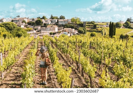 Woman enjoying Saint Emilion village in green vineyard, Bordeaux in France Royalty-Free Stock Photo #2303602687