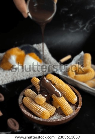 dark chocolate dipping sauce homemade churros in black marble background for brakfast Royalty-Free Stock Photo #2303613059