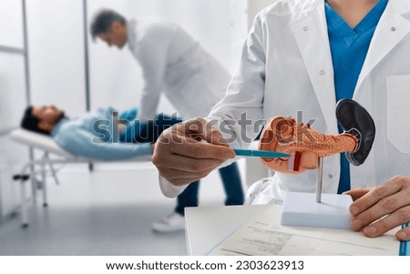 Doctor palpates man patient abdomen and examines belly in medical clinic to analyze condition of pancreas. Treatment of pancreatic diseases, acute and chronic pancreatitis Royalty-Free Stock Photo #2303623913