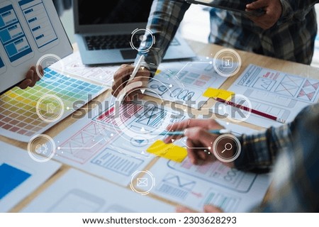  UX developer and ui designer brainstorming about mobile app interface wireframe design with customer breif and color code at modern office. with virtual icon diagram

