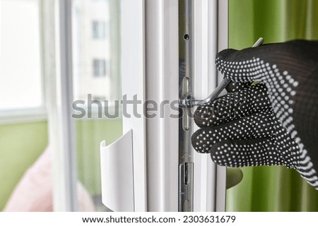 With the help of a hexagon, the pressure of the window sash is adjusted. Maintenance of metal-plastic windows. Royalty-Free Stock Photo #2303631679