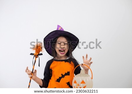 Funny child girl in witch costume for Halloween with pumpkin and witch broom.