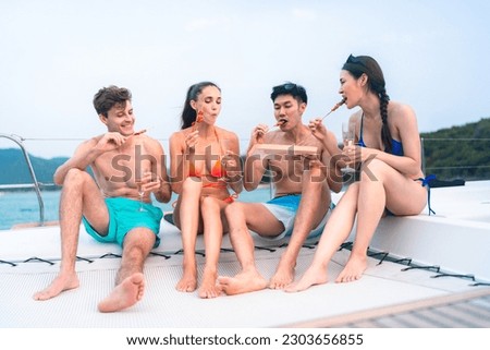 happy man in swimwear and woman in bikini having laugh fun in summer trip with friends group by eat bar-b-q grill and wine party drink, friendship vacation travel on sailboat yacht at the ocean sea