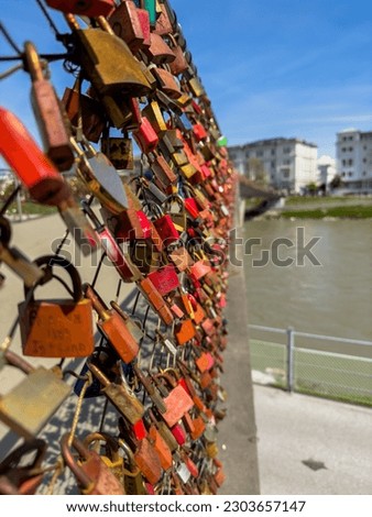 Under the shining light are love locks on a bridge over the Salzach in Salzburg