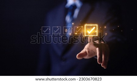 Businessman ticking checkmark on a box in the list Show on the virtual screen. Checklist Ideas in Business Survey items and questionnaires. copy space Royalty-Free Stock Photo #2303670823