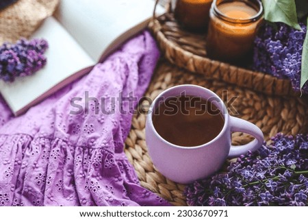 Cup of hot tea and lilac bouquet, good morning concept.