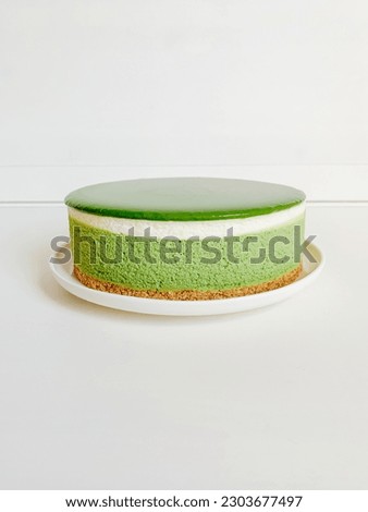 Layered matcha cheesecake on white background. Copy space for text. Gluten free no bake dessert. Healthy sweet food.