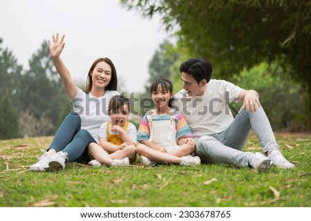 Young Asian family in the park Royalty-Free Stock Photo #2303678765