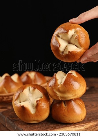 Laugenbrezel(Brezen),Lye bread in the shape of a peach with a cross cut in the middle, on a dark background