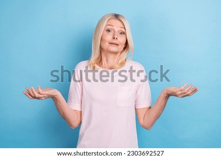Portrait of clueless confused pensioner woman bob hairstyle wear white t-shirt shrugging shoulders isolated on blue color background Royalty-Free Stock Photo #2303692527