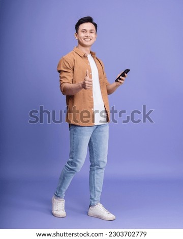 Photo of young Asian man on background Royalty-Free Stock Photo #2303702779