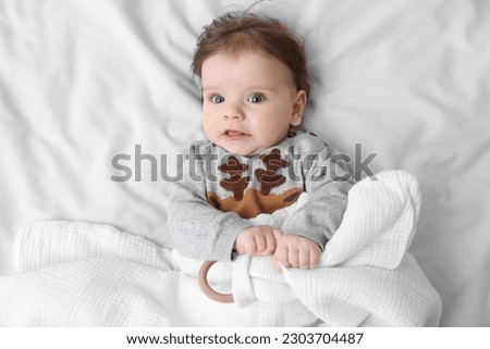 Cute little baby on soft bed, top view
