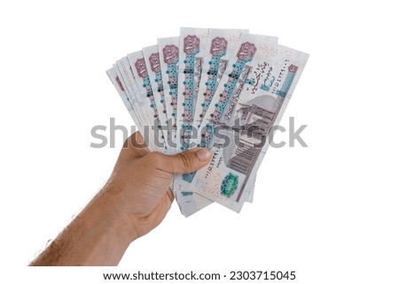 hand holding Egyptian money isolated on white background Royalty-Free Stock Photo #2303715045