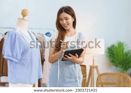 Online marketing concept, Asian women selling clothes in streaming video and check orders on tablet.