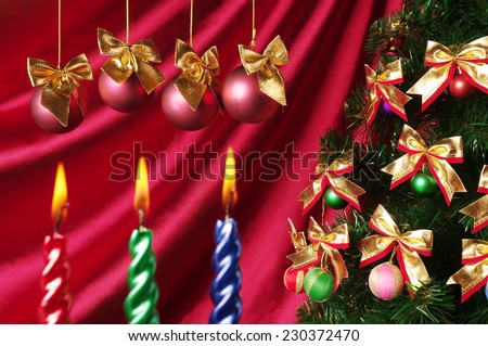 Three New year candles on the purple drapery and christmas tree