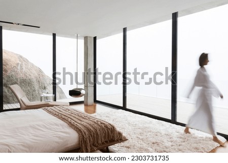 Blurred view of woman wearing bathrobe in bedroom