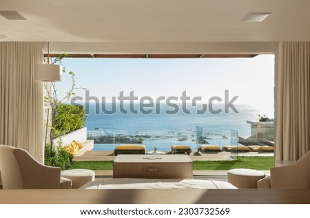 Sunny bedroom and patio overlooking ocean Royalty-Free Stock Photo #2303732569