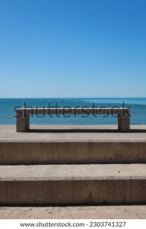 stone bench with sea view on sunny day and calm sea