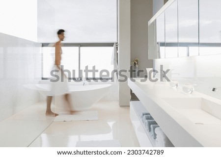 Man in towel walking in bathroom