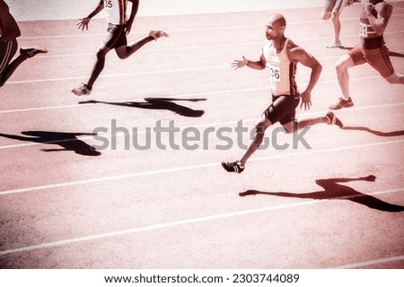 Track and field runners racing on track