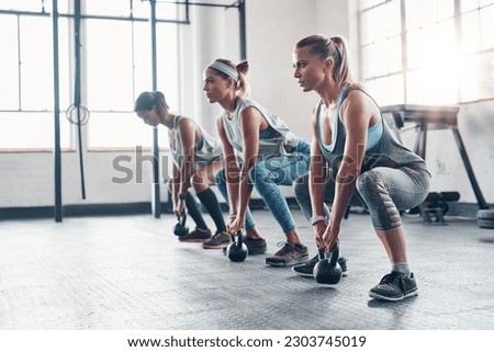 Kettlebell, training and women with workout, exercise and performance for wellness, healthy lifestyle or self care. Female athletes, friends or group with gym equipment, sports and stretching routine Royalty-Free Stock Photo #2303745019