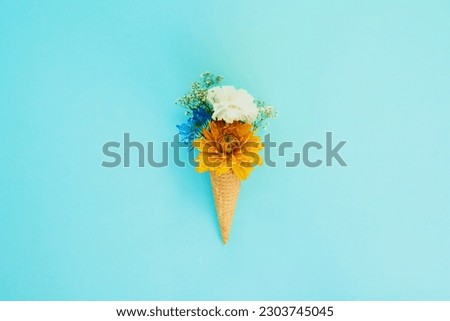 Floral, ice cream and cone in studio for creativity, art or decoration with fresh and colorful bouquet. Creative, still life and flower plants in dessert isolated by blue background with mockup space